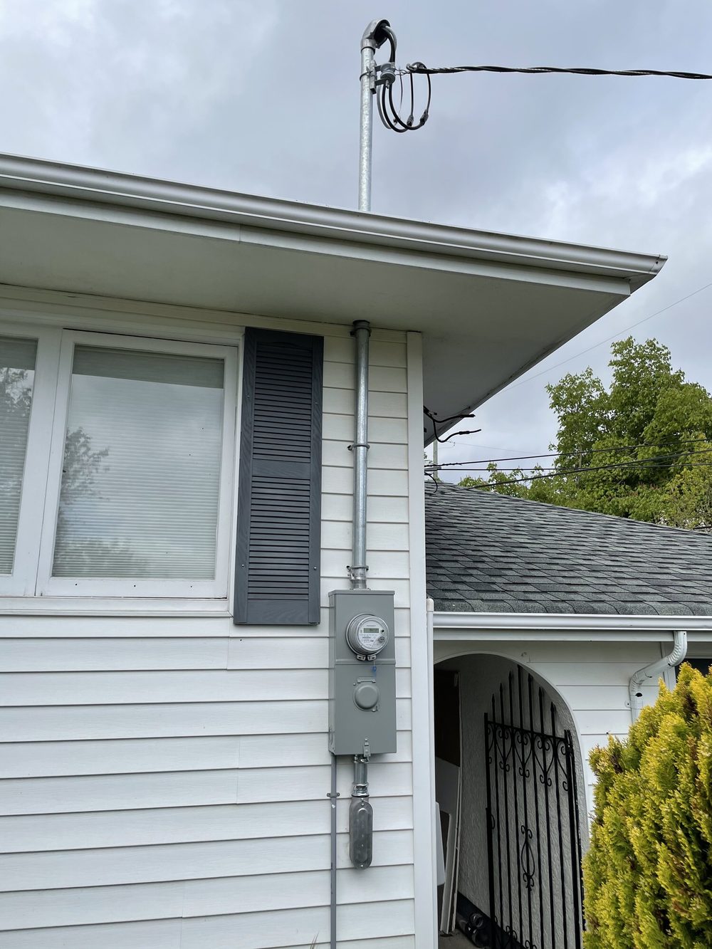 Overhead electrical service mast and meter base on a Victoria home